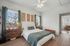 Inviting bedroom with natural light, cozy bedding, and stylish wooden furniture, perfect for relaxation.