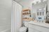 Bright and modern bathroom featuring elegant fixtures, ample storage, and a large vanity mirror.