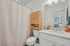 Elegant and bright bathroom featuring a stylish vanity, ample storage, and contemporary fixtures.