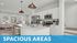 Modern kitchen with sleek white cabinetry, stainless steel appliances, and a spacious island leading to an airy living room with large windows and chic decor.