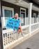 Charming front porch with welcoming sign at Mitchell Yards, featuring cozy railing and inviting entrance.