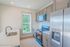 Modern kitchen with sleek stainless steel appliances, large window, and stylish cabinetry offering a fresh, bright space.