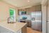 Modern kitchen with sleek stainless steel appliances, elegant cabinetry, and a bright window view, perfect for culinary inspiration and entertaining.
