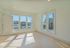 Bright and airy room with large windows offering natural light and a serene street view, perfect for a cozy living space.