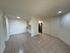 Bright and welcoming open-plan area with tiled flooring, featuring a modern kitchen and ample natural light, perfect for city living.