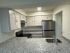 Modern kitchen with elegant granite countertops, sleek stainless steel appliances, and ample cabinet space for a stylish cooking experience.