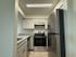 Modern kitchen with sleek stainless steel appliances, bright lighting, and elegant granite countertops.