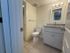 Modern bathroom featuring elegant tile flooring, a sleek granite countertop sink, and bright vanity lighting.