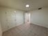 Bright and spacious room with elegant tiled flooring and freshly painted walls, featuring modern door accents, perfect for a cozy retreat or office space.