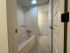 Modern bathroom with sleek tiled flooring and a pristine bathtub, creating a serene and inviting atmosphere.
