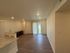 Inviting living space with modern hardwood flooring, open layout, and abundant natural light through glass doors.