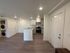 Chic open-plan living space with modern kitchen, sleek flooring, and in-unit laundry for ultimate convenience.