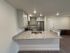 Contemporary kitchen with sleek granite countertops, modern white cabinetry, and stainless steel appliances.