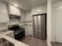 Modern kitchen with sleek stainless steel appliances, elegant granite countertops, and pristine white cabinetry offering ample storage.