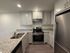 Modern kitchen with sleek stainless steel appliances, elegant granite countertops, and crisp white cabinetry, offering a sophisticated and functional space.