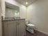 Modern bathroom with sleek granite countertop, elegant vanity, and spacious shower area in a bright, inviting setting.
