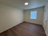 Bright and inviting bedroom featuring elegant hardwood flooring and a large window with natural light.