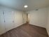 Bright and modern room with elegant wood flooring, featuring sleek white doors and freshly painted walls.