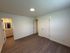 Bright and inviting bedroom with modern wood flooring, elegant white walls, and chic recessed lighting alongside an en suite bathroom for ultimate comfort.