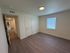 Bright, spacious bedroom with modern wooden flooring and large window offering abundant natural light.
