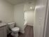Modern bathroom with sleek fixtures, featuring a bathtub with crisp white tiles and elegant dark wood flooring.