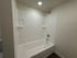 Bright modern bathroom featuring a sleek bathtub with elegant white tiling and contemporary fixtures.