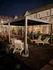 Elegant outdoor patio area at night with comfortable lounge chairs and a modern gazebo, offering tranquil living.