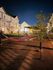 Charming nighttime courtyard with inviting hammocks and stylish townhouses, perfect for relaxation and community gatherings.
