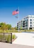 Modern apartment complex with stylish exterior, surrounded by lush greenery and vibrant landscaping, highlighted by a bright blue sky.