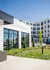 Contemporary apartment complex featuring modern architecture with large windows, lush landscaping, and inviting outdoor spaces on a sunny day.