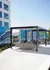 Chic outdoor lounge area with modern seating, vibrant mural art, and sleek pergola, perfect for relaxing or entertaining.