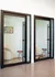 Modern office space with stylish glass doors, cozy seating, and vibrant artwork, inviting for creativity.