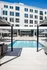 Luxurious apartment complex featuring a refreshing pool, ample lounge chairs, and sleek modern architecture with expansive windows.