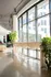 Bright, modern interior with floor-to-ceiling windows, sleek bar stools, and lush greenery, offering a stylish urban living space.