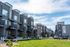 Brick townhomes at Erin Hills Estates with balconies overlooking a large green lawn.
