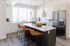 Townhome kitchen with white cabinets, quartz island, bar stools and stainless steel appliances at Erin Hills Estates