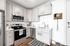 Apartment kitchen with quartz countertops, stainless steel appliances and gray cabinetry at Tradition Pointe