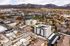 Scenic aerial view of modern apartment complex surrounded by lush greenery and mountains at Tradition Pointe