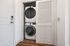 Modern apartment feature showcasing a sleek stacked washer and dryer unit tucked behind a stylish sliding door at Tradit