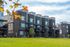 Brick townhomes at Erin Hills Estates framed by fall foliage and a large green lawn.