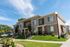 Two-story townhomes with brick accents, covered porches, and landscaped front yards at Erin Hills Estates.