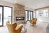 Clubhouse sitting area with a stone fireplace and accent chairs at The Residences at Victory Ranch in Idaho Falls