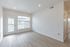 3-bedroom apartment living room with balcony door and large window at The Residences at Victory Ranch in Idaho Falls