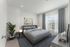 Furnished second bedroom with a queen bed and large window at The Residences at Victory Ranch in Idaho Falls
