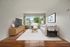 Bright and inviting living room with elegant decor, featuring a large window with scenic views, plush sofa, and modern entertainment center.