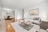 Elegant open-concept living and dining area featuring sleek hardwood floors, modern furniture, and tasteful artwork.