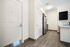 Modern apartment entryway featuring sleek hardwood floors, stainless steel appliances, and elegant lighting.