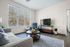 Bright and inviting living room with a comfy couch, elegant armchair, and large window offering scenic views, perfect for relaxation.