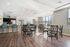 Modern apartment community space featuring elegant hardwood floors, a stylish kitchen with stainless steel appliances, and a bright seating area with abundant natural light.