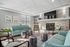 Bright, inviting living room with contemporary seating, stylish decor, and a cozy stone fireplace, perfect for relaxation.